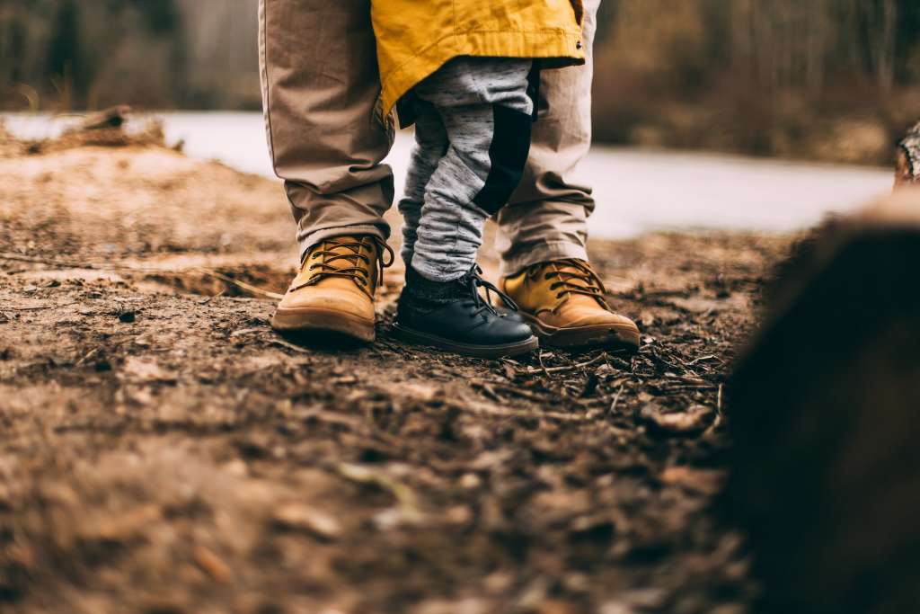 Father and son's feet on a trail in The Woodlands.