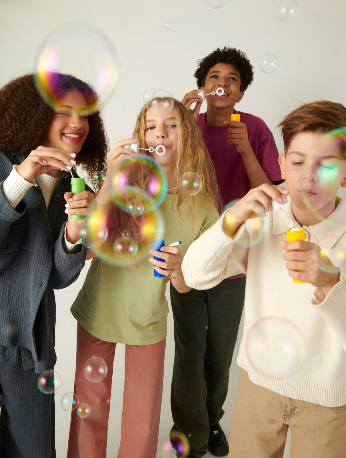 kids blowing bubbles at camera