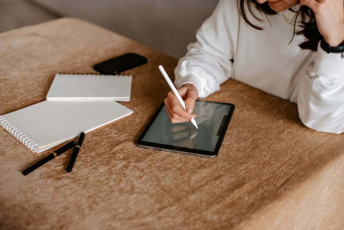 woman writing on a tablet with a tablet pen